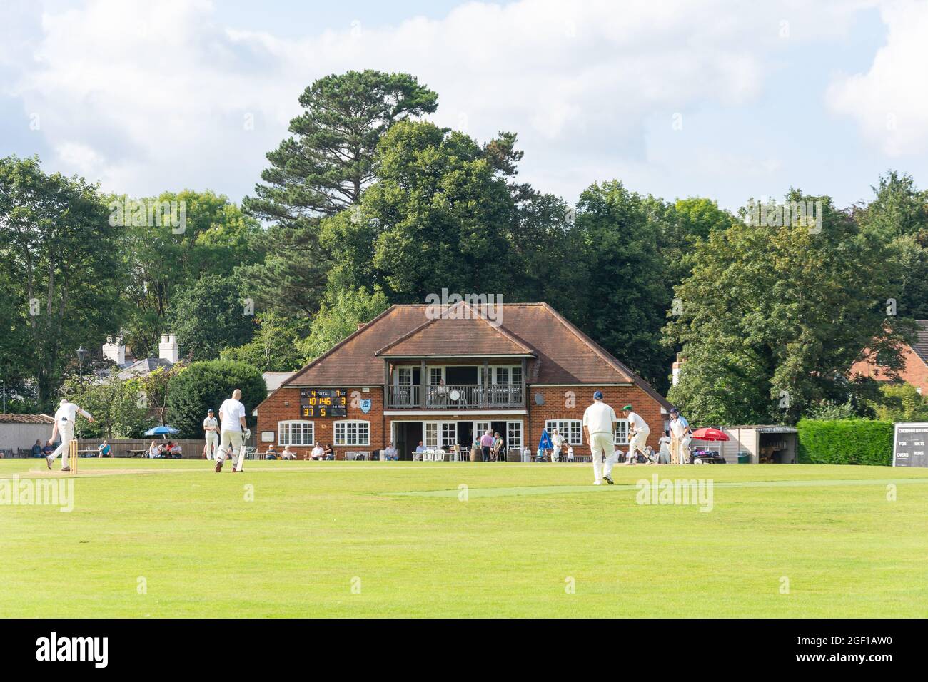 Partita di cricket locale e Pavilion, Chobham Cricket Club Ground, Chobham, Surrey, Inghilterra, Regno Unito Foto Stock