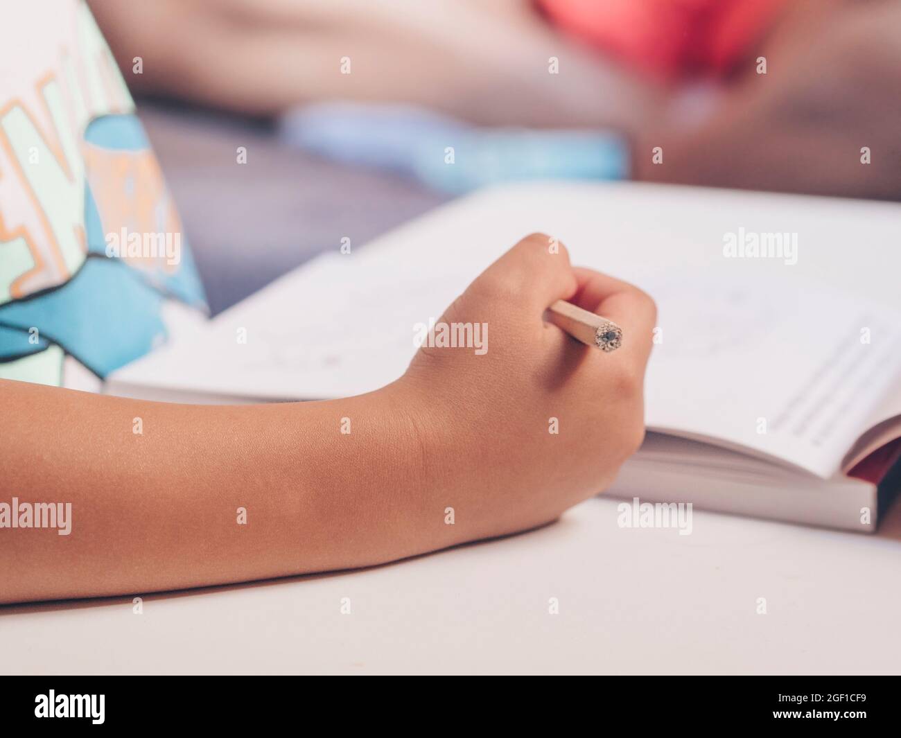 Primo piano della mano del bambino con la matita. Ritorno a scuola, istruzione. Foto Stock