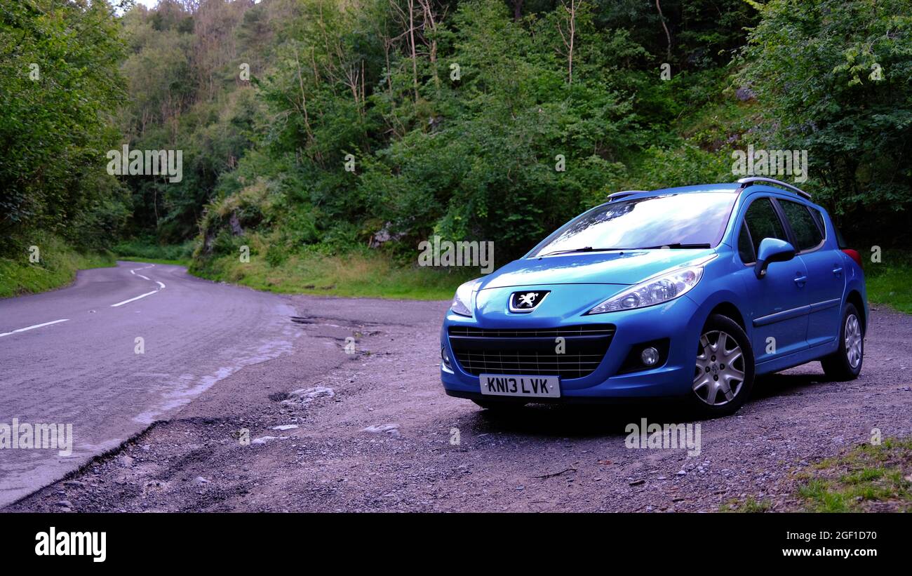 2021 agosto - Blue Peugeot 207 SW auto parcheggiata a Cheddar Gorge da un turista che visita la famosa gola Foto Stock