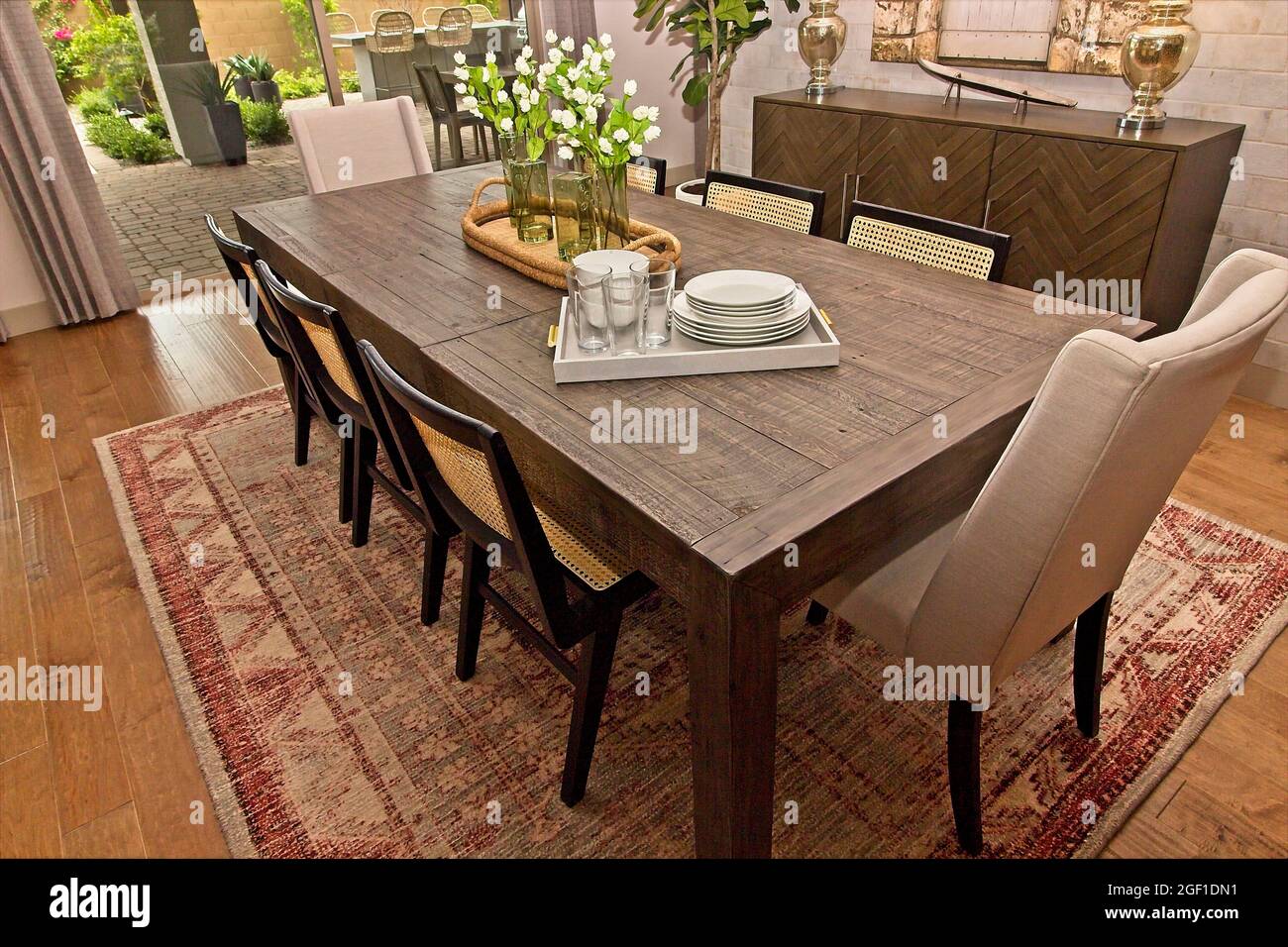 Tavolo da pranzo in legno con otto sedie Foto Stock