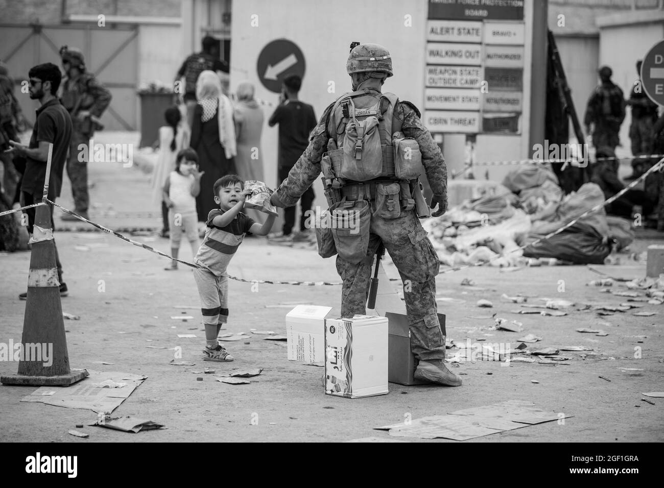 HAMID KARZAI INTERNATIONAL AIRPORT, Afghanistan (20 agosto 2021) UNA Marina con la 24a unità Marine Expeditionary (MEU) fornisce un pasto pronto a mangiare a un bambino durante un'evacuazione all'Aeroporto Internazionale Hamid Karzai, Kabul, Afghanistan, 20 agosto. I membri del servizio degli Stati Uniti stanno assistendo il Dipartimento di Stato con un prelievo ordinato di personale designato in Afghanistan. (STATI UNITI Foto del corpo marino di Sgt. Samuel Ruiz)via American PhotoArchive/Alamy) Foto Stock