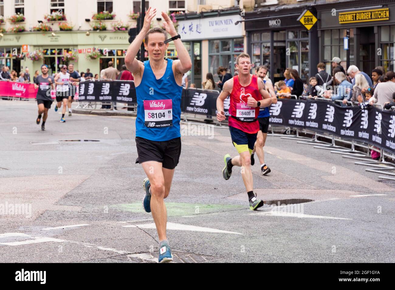 Il runner stringe le mani avvicinandosi al traguardo al Cutty Sark London Greenwich , GRANDE mezza maratona 2021 UK Foto Stock