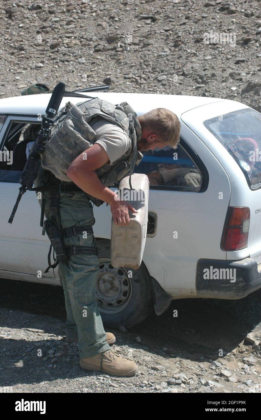 Un soldato di intelligence che lavora con la sede centrale e la sede centrale Troop, 4 ° Squadron, 73 ° reggimento Cavalry, 4 ° Brigade Combat Team, 82nd Airborne Divison, aiuta un locale ottenere la sua auto ha iniziato il 04 giugno 2007 nel distretto Andar della provincia di Ghazni, in Afghanistan. Foto dell'esercito degli Stati Uniti di Sgt. Matthew Clifton (rilasciato) Foto Stock