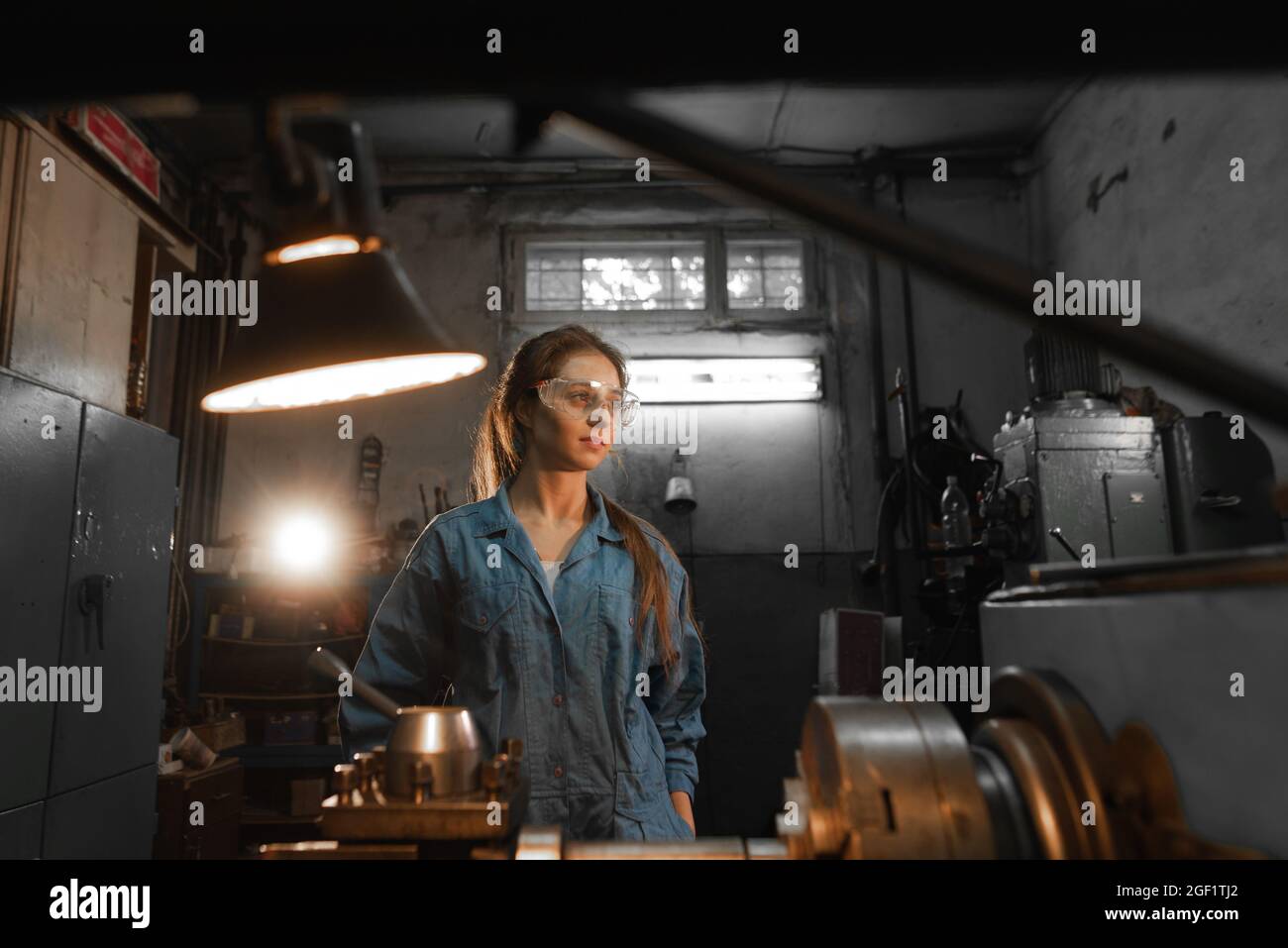 Donna studente lavora su un tornio automatico CNC, laboratorio industriale. Concetto di educazione professionale Turner. Foto Stock