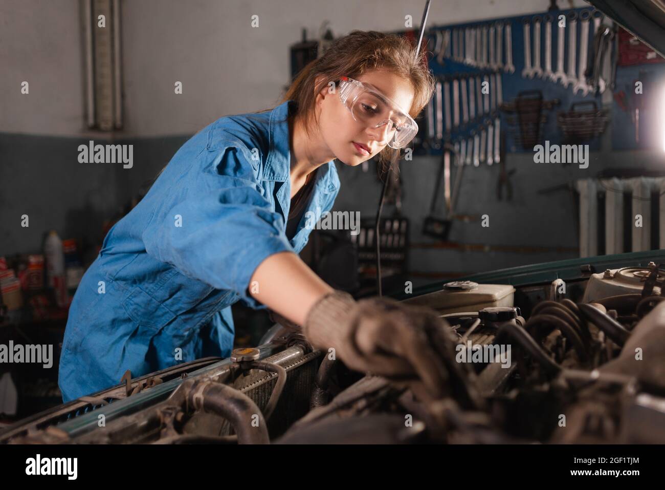 Riparazione meccanica del motore o parti elettriche di una vettura in un garage Foto Stock