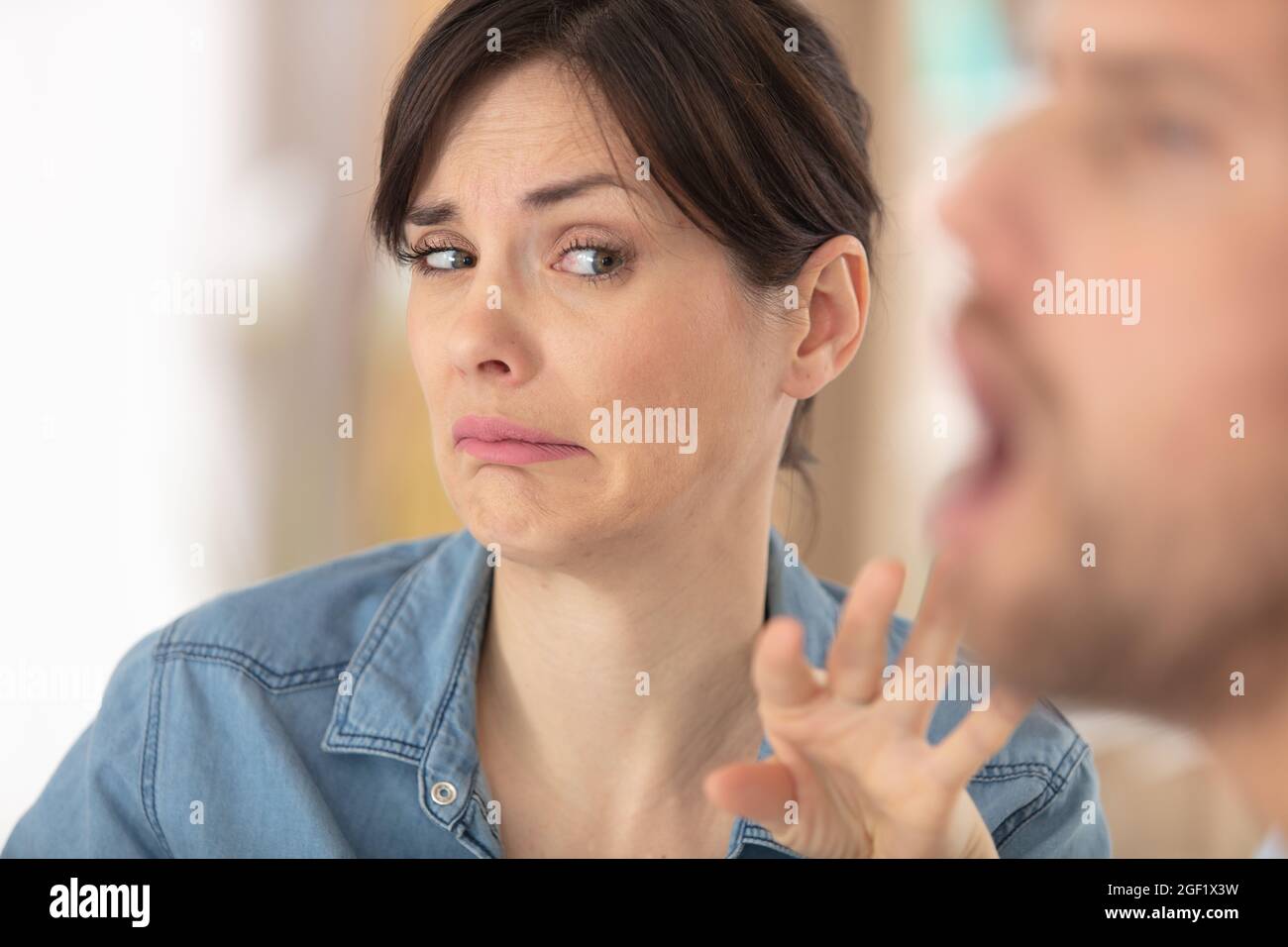 la donna fa espressione disgustosa accanto all'uomo con bocca aperta Foto Stock