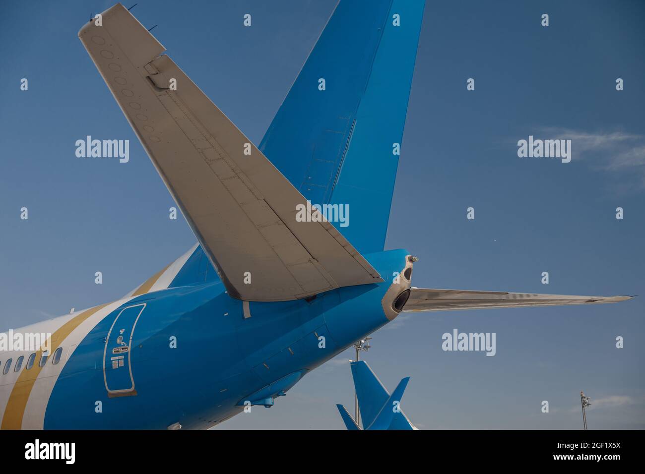 Coda di un aereo in aeroporto con cielo blu sullo sfondo Foto Stock