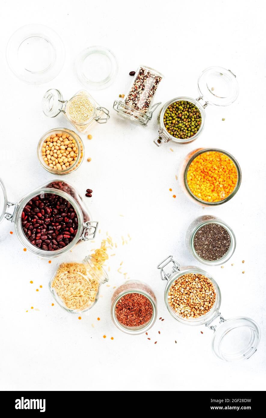 Drogheria, scorte domestiche in plastica di deposito libero e vasi. Fagioli vari, grani, cereali, legumi, semi in lattine riutilizzabili. Tavola bianca. Zero rifiuti e su Foto Stock