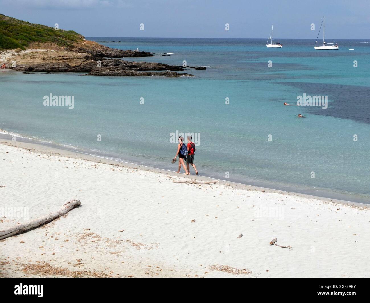 Coppia uomo e donna che camminano sulla spiaggia di sabbia bianca di Cala Genovese vicino a Macinaggio, Corsica nord-orientale, Francia Foto Stock