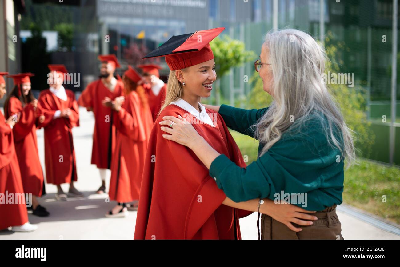 Ritratto di allievo universitario allegro con professore superiore che celebra all'aperto, concetto di laurea. Foto Stock