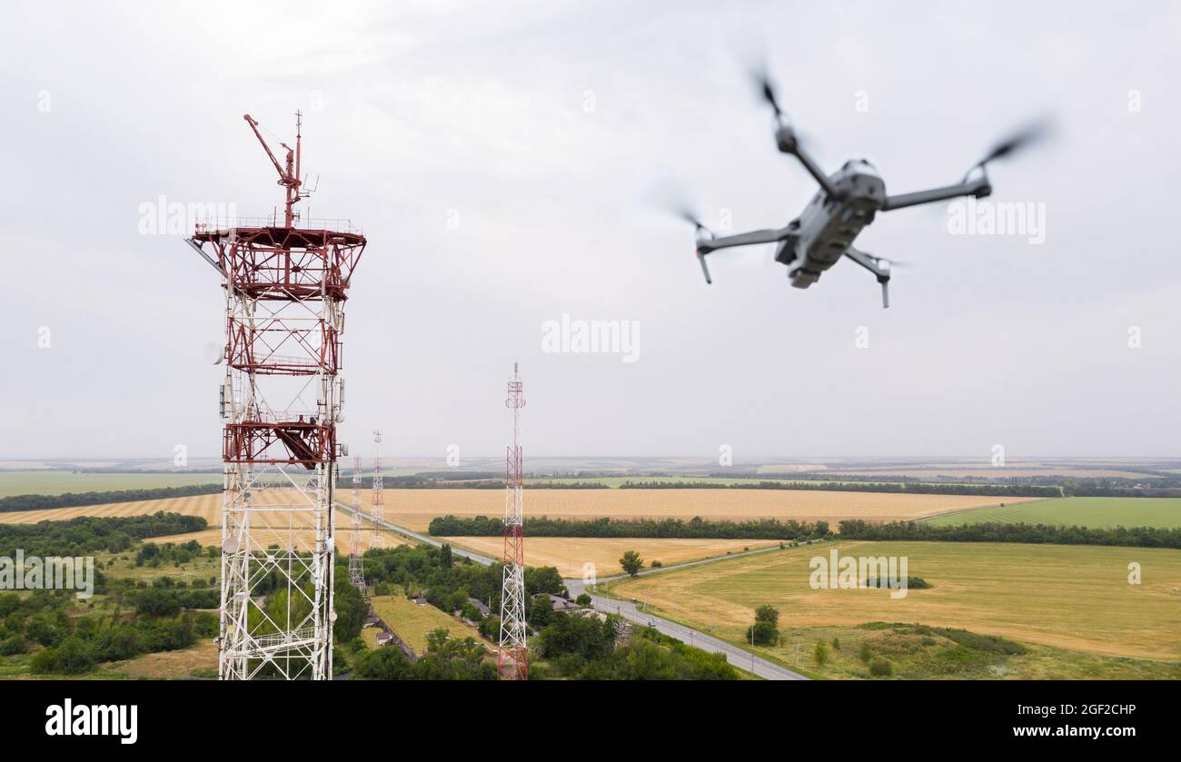 Il drone sorvola le torri di telecomunicazione in campagna Foto Stock