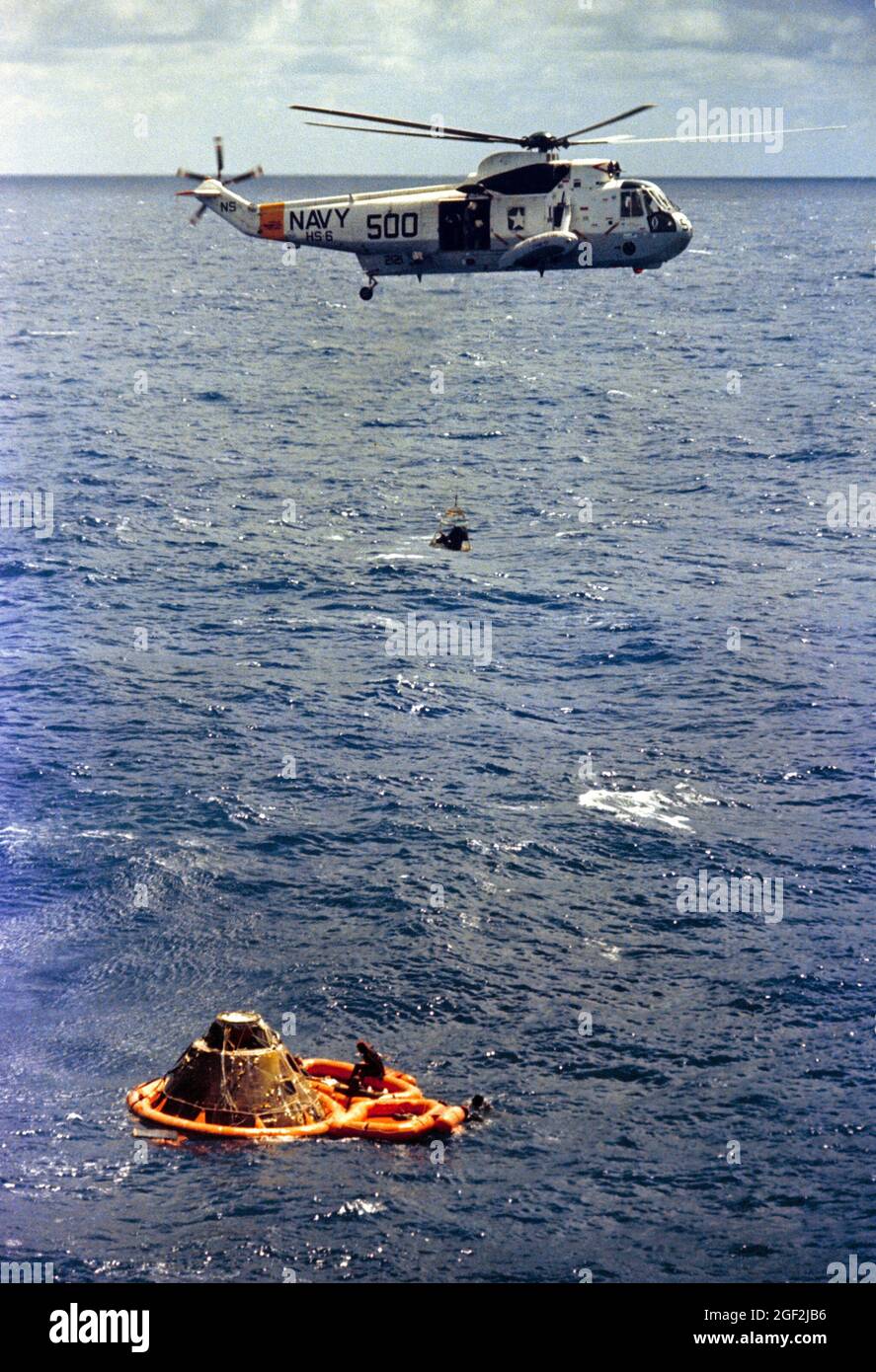 (9 feb. 1971) --- Astronauta Stuart A. Roosa, pilota del modulo di comando, è issato all'interno di una rete di Billy Pugh ad un elicottero della Marina degli Stati Uniti che assiste nelle operazioni di recupero di Apollo 14 nell'Oceano Pacifico del Sud. In una zattera di salvataggio accanto al modulo di comando (CM) sono visibili gli astronauti Alan B. Shepard Jr., comandante, ritorno alla macchina fotografica; ed Edgar D. Mitchell (parzialmente oscurato dalla navicella spaziale), pilota del modulo lunare. Tre nuotatori della squadra di demolizione subacquea della Marina degli Stati Uniti che hanno assistito nelle operazioni di recupero sono raffigurati dentro e intorno alla zattera di salvataggio. Foto Stock