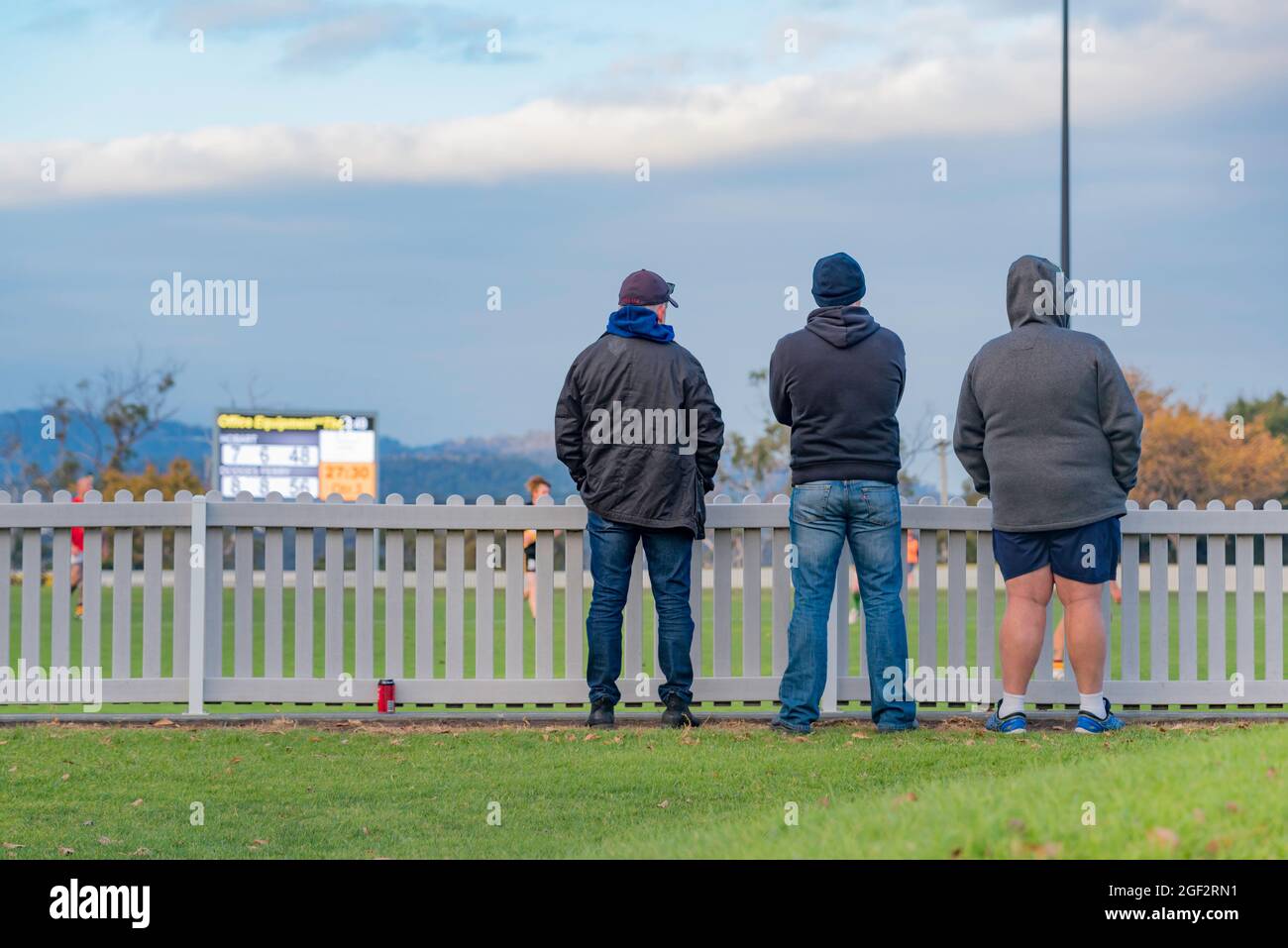 Un gruppo molto piccolo (3) tifosi guarda una partita di Australian Football (AFL) tra Hobart e Dodges Ferry Club al TCA Ground di Hobart, Tasmania Foto Stock