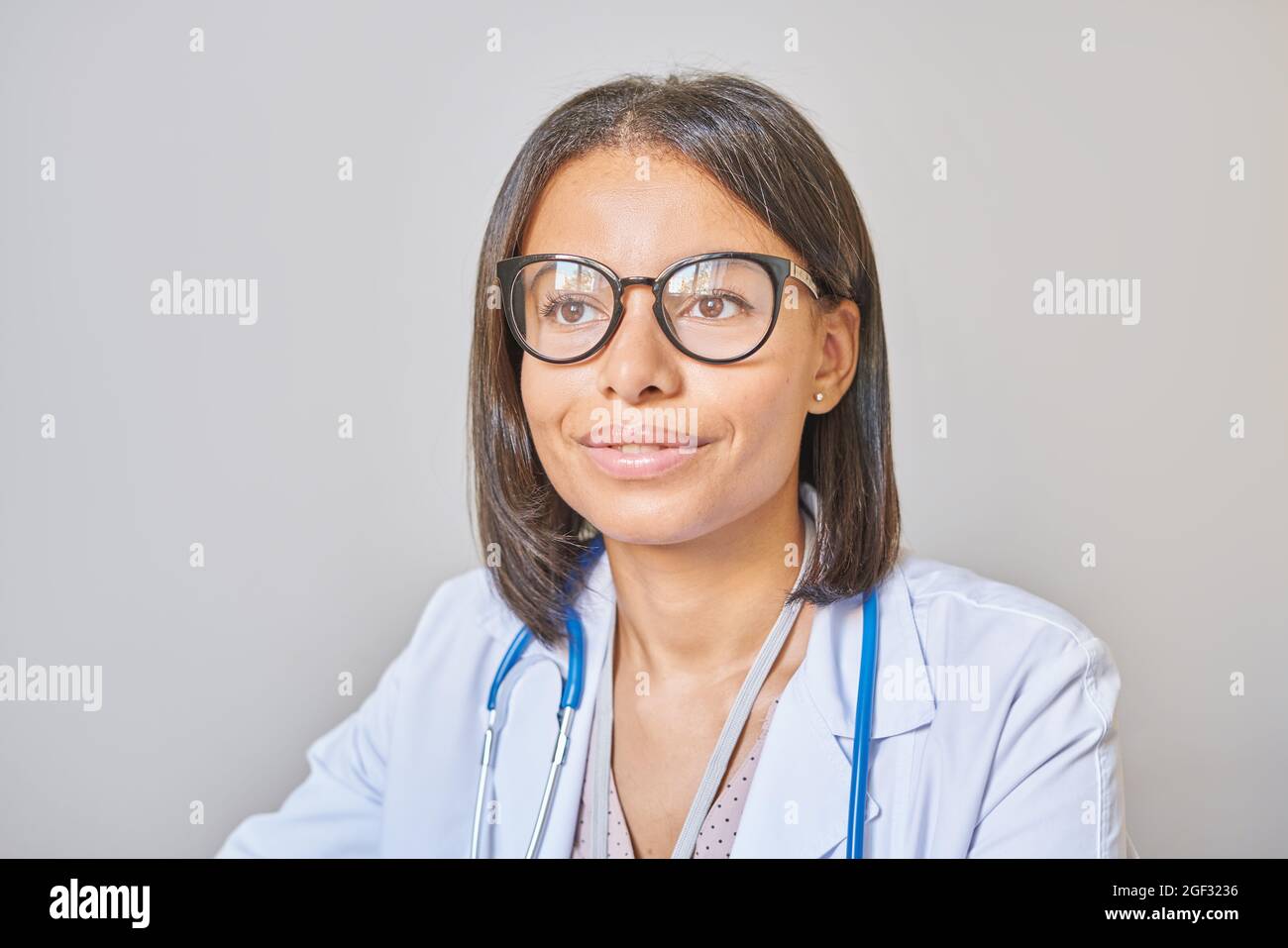 Sorridente afroamericana medico professionista in occhiali con stetoscopio sulle spalle al lavoro Foto Stock