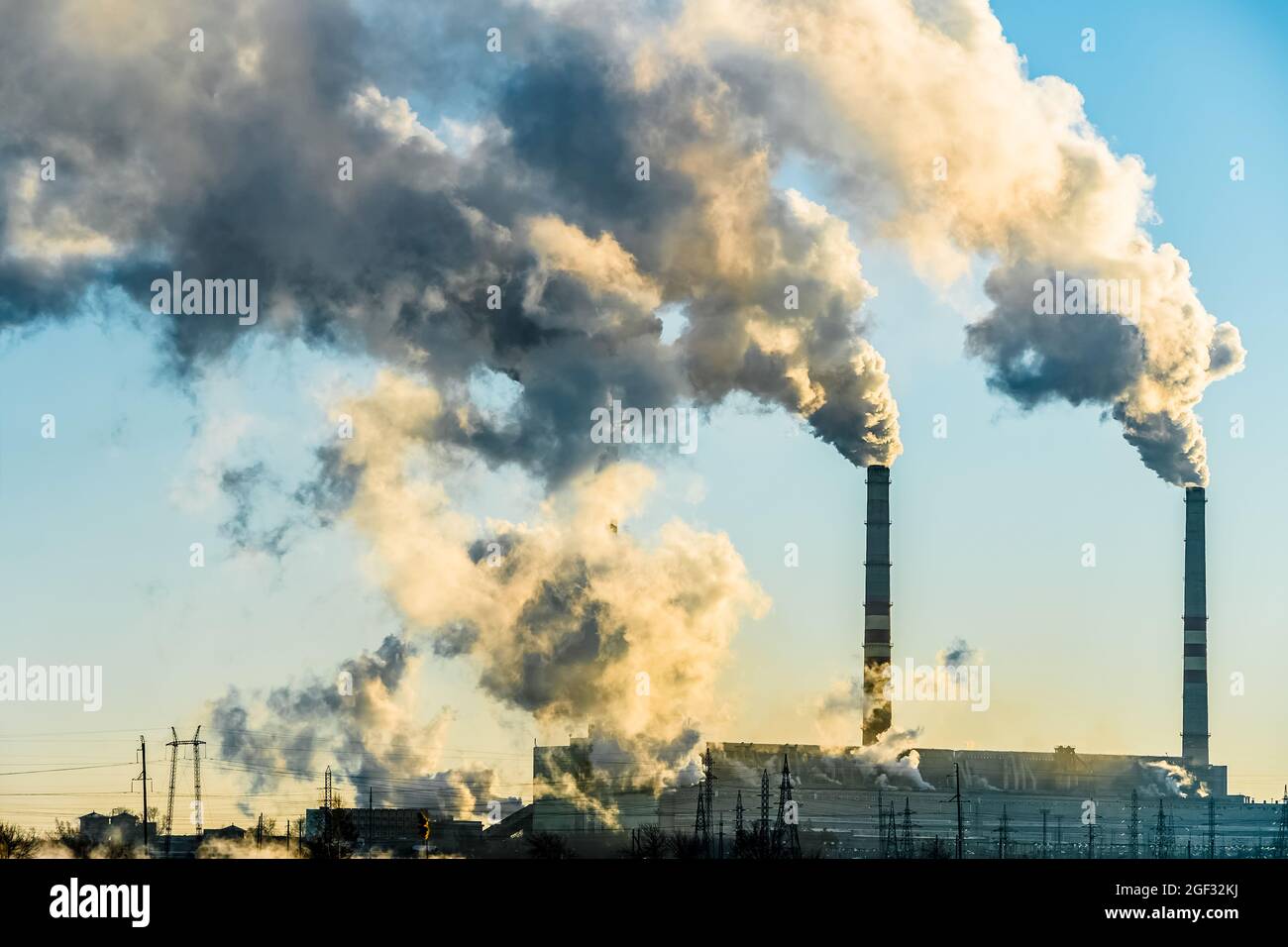 Tramonto sulla città industriale. Camini di fabbrica fumo. Problema ambientale di ambiente E inquinamento atmosferico. Cambiamento climatico, ambientale d Foto Stock