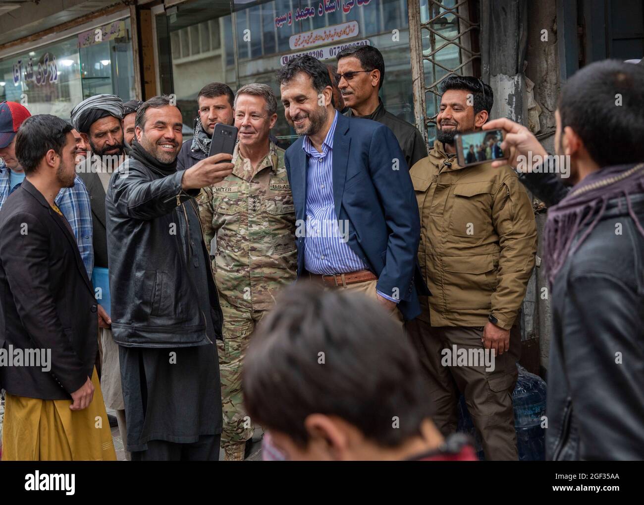 Il comandante dell'esercito statunitense Scott Miller e il ministro afghano della Difesa Aguadullah Khalid prendono selfie con i residenti nel centro di Kabul il 26 febbraio 2020, durante la riduzione di sette giorni della violenza che ha preceduto la firma dell'accordo di pace tra Stati Uniti e talebani a Kabul, Afghanistan. Gli Stati Uniti e i talebani hanno firmato l'accordo del 29 febbraio per portare la pace in Afghanistan dopo più di 18 anni di conflitto. (STATI UNITI Foto della riserva dell'esercito da SPC. Jeffery J. Harris/ rilasciato) Foto Stock