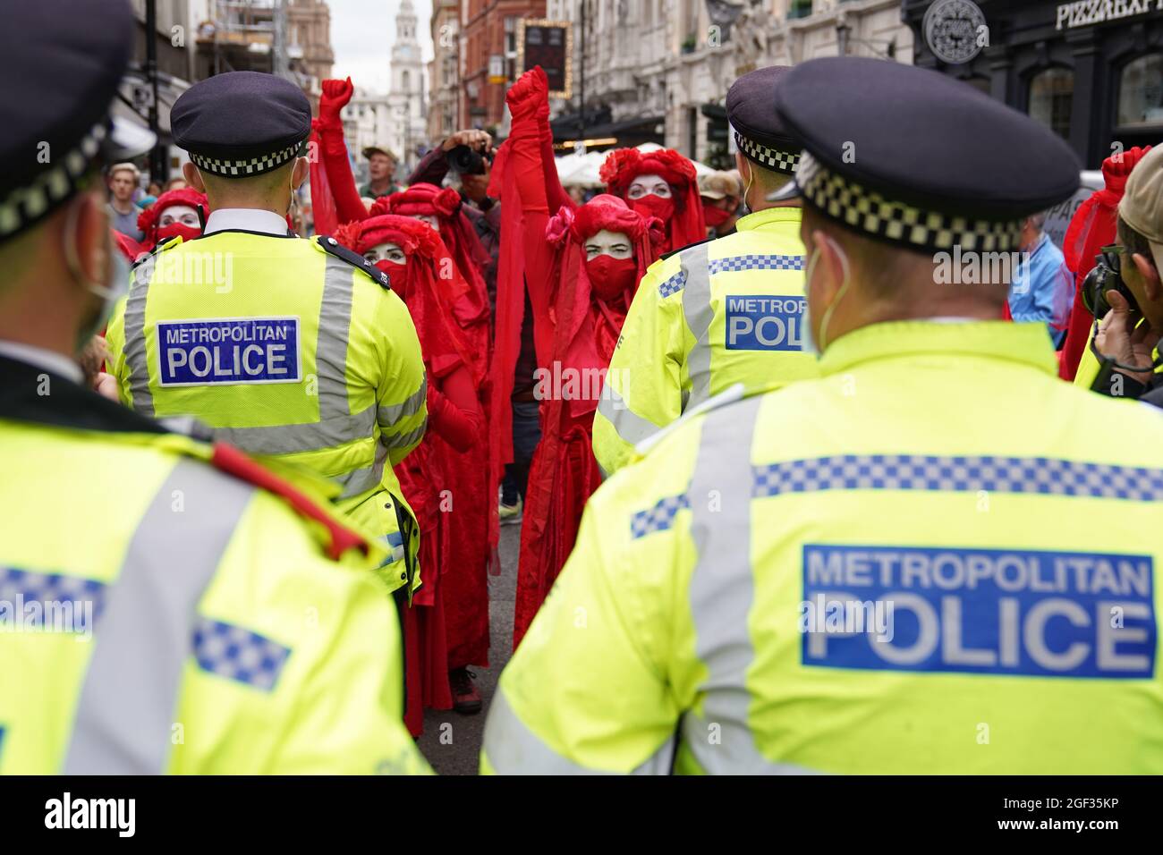 I ribelli rossi si riuniscono durante una protesta da parte dei membri della Rebellion di estinzione a St Martin's Lane, nel centro di Londra, all'inizio di una prevista azione di due settimane da parte del gruppo di protesta del cambiamento climatico. Data foto: Lunedì 23 agosto 2021. Foto Stock