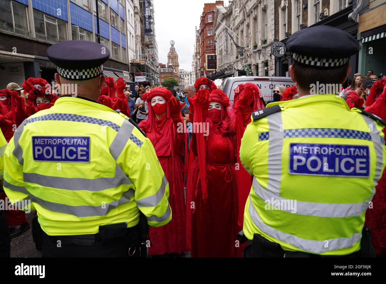 I ribelli rossi stanno ostacolando la polizia durante una protesta da parte dei membri della Rebellion di estinzione a St Martin's Lane, nel centro di Londra, all'inizio di una prevista azione di due settimane da parte del gruppo di protesta per il cambiamento climatico. Data foto: Lunedì 23 agosto 2021. Foto Stock