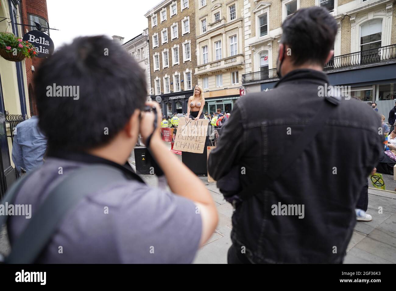 Un dimostratore con adesivi posizionati strategicamente si unisce alla folla durante una protesta da parte dei membri della Extinction Rebellion su St Martin's Lane, nel centro di Londra, all'inizio di due settimane di azione previste dal gruppo di protesta del cambiamento climatico. Data foto: Lunedì 23 agosto 2021. Foto Stock