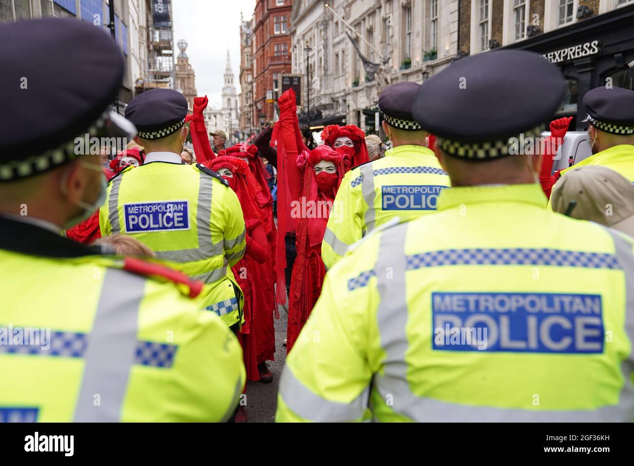 I ribelli rossi stanno ostacolando la polizia durante una protesta da parte dei membri della Rebellion di estinzione a St Martin's Lane, nel centro di Londra, all'inizio di una prevista azione di due settimane da parte del gruppo di protesta per il cambiamento climatico. Data foto: Lunedì 23 agosto 2021. Foto Stock