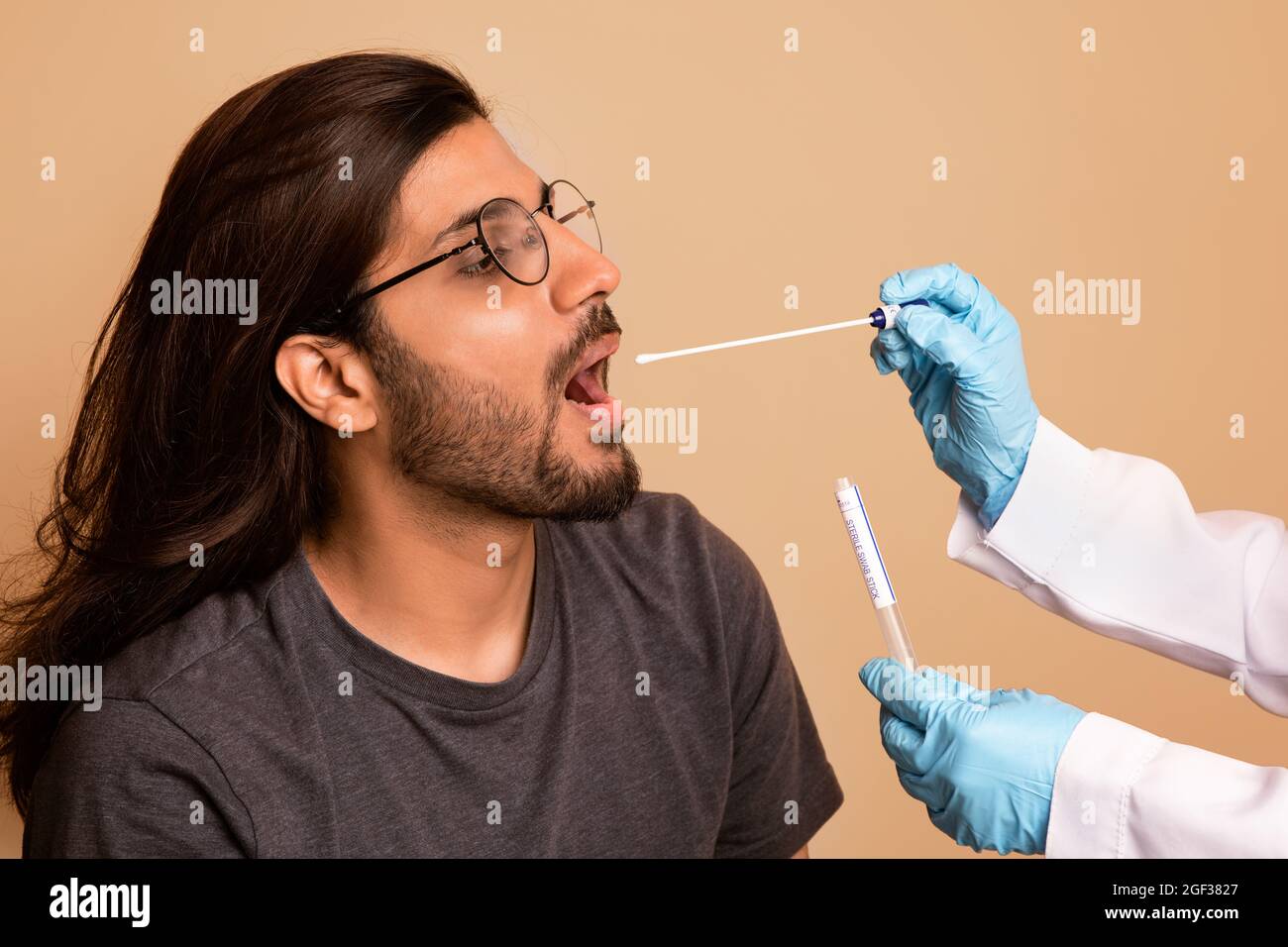 Infermiere che prende il tampone orale per il campione di coronavirus da uomo indiano Foto Stock