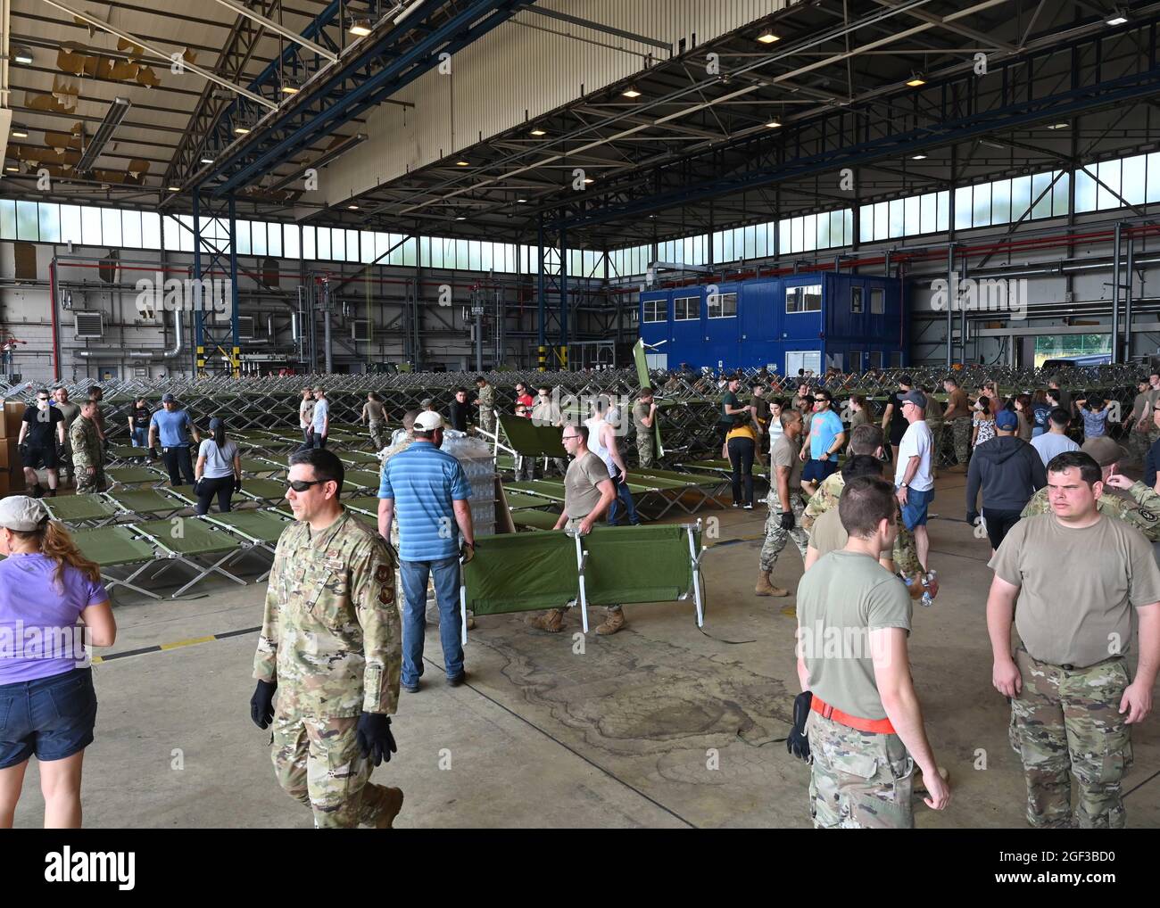 I volontari assemblano altre culle all'interno di un hangar alla base aerea di Ramstein, Germania, 21 agosto 2021. La base aerea di Ramstein fornisce alloggi sicuri e temporanei per gli sfollati dall'Afghanistan come parte del Refuge Operation Allees. Questa operazione sta facilitando l'evacuazione rapida e sicura dei cittadini degli Stati Uniti, dei richiedenti di visti speciali per immigrati e di altri afghani a rischio dall'Afghanistan. Gli evacuati riceveranno supporto, come alloggio temporaneo, cibo e acqua, accesso alle cure mediche e alle cure religiose presso la base aerea di Ramstein, mentre si preparano per i movimenti successivi verso le loro destinazioni finali. (STATI UNITI Aria per Foto Stock
