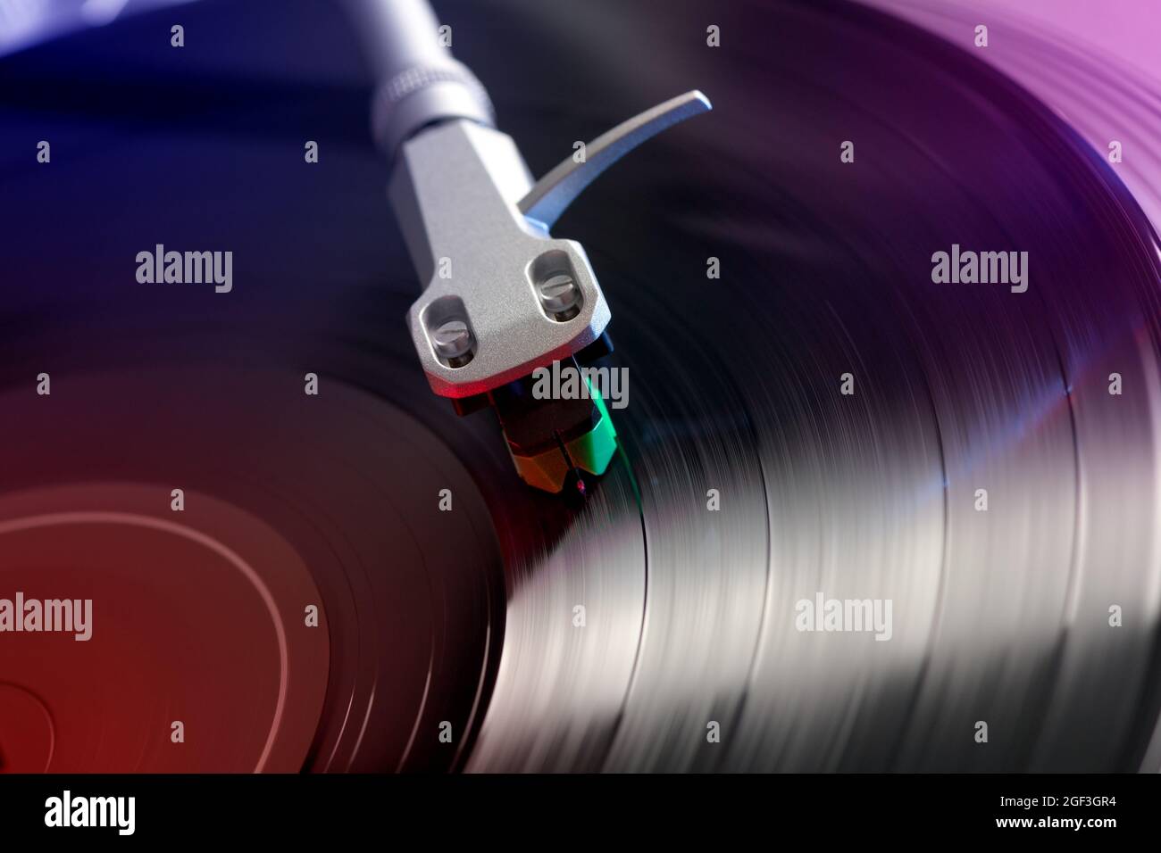 vista ravvicinata di un disco in vinile riprodotto su un giradischi, illuminazione colorata Foto Stock