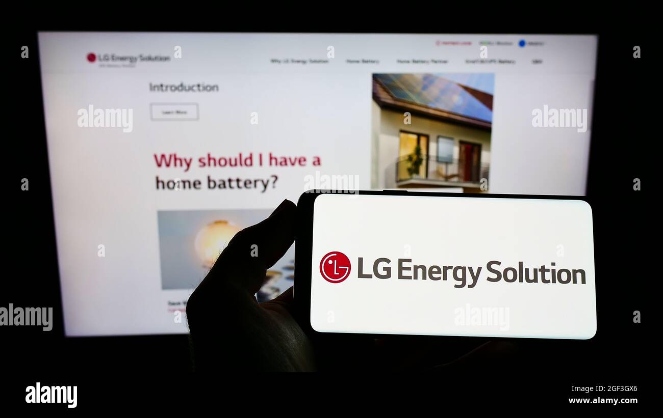Persona che tiene lo smartphone con il logo della società di batterie LG Energy Solution Ltd. Sullo schermo di fronte al sito Web. Mettere a fuoco sul display del telefono. Foto Stock