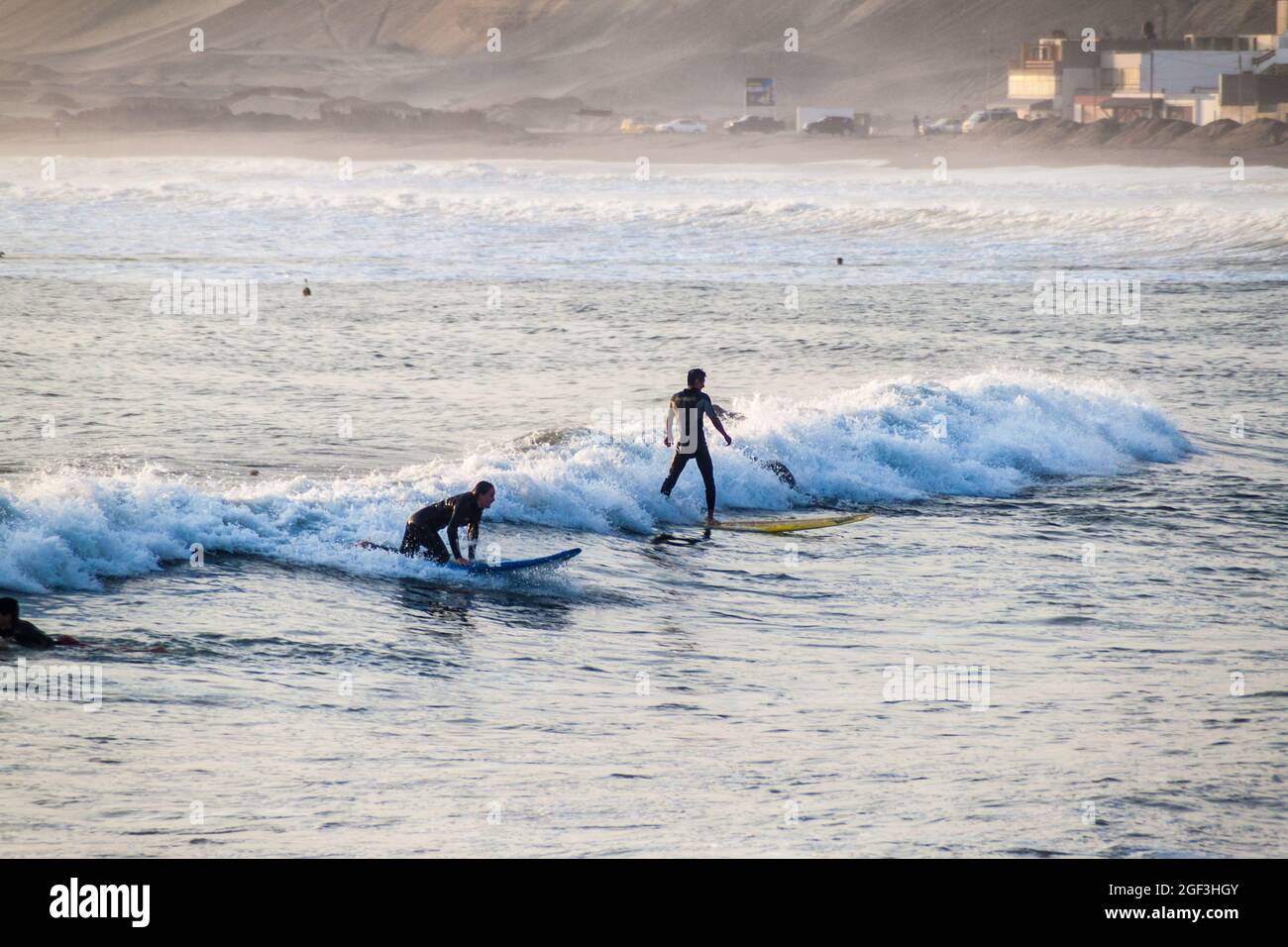 HUANCHACO, PERÙ - 6 GIUGNO 2015: La gente naviga nelle onde di un oceano a Huanchaco, Perù. Foto Stock