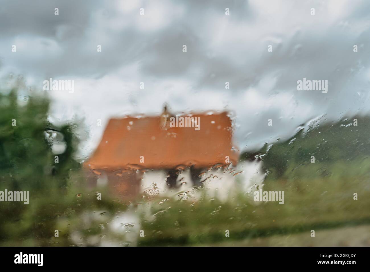 Gocce su vetro su moody day.Rain piovoso fuori finestra sfocato casa. Texture of raindrops, wet glass.Rainy window background.View through window Foto Stock