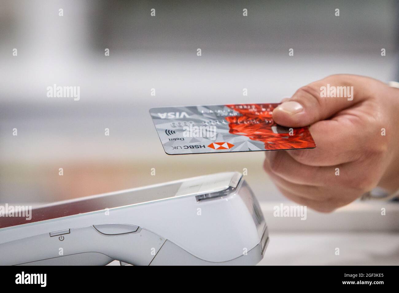 Primo piano di una carta di debito bancaria utilizzata per l'acquisto tramite contactless. Foto Stock