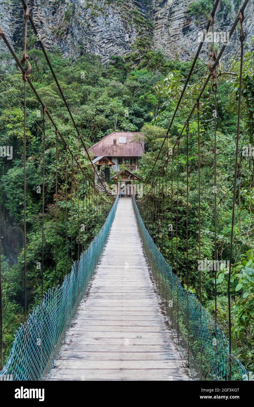 Ponte di Suspnsion che attraversa la cascata Pailon del Diablo (Cauldron del Diavolo) vicino alla città di Banos, Ecuador Foto Stock