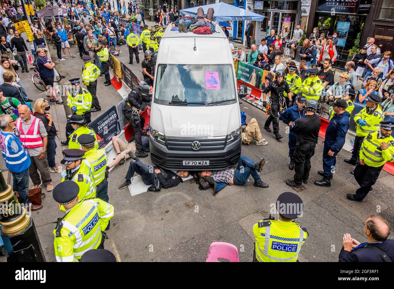 Londra, Regno Unito. 23 Agosto 2021. La polizia ha indosso un furgone disabile con persone attaccate ad esso, che blocca una delle strade - iniziano con attenzione a rimuovere i manifestanti. Estinzione la ribellione inizia due settimane di protesta, sotto l'impossibile nome della ribellione, a Londra. Coincide anche con l'anniversario della ribellione haitiana. Credit: Guy Bell/Alamy Live News Foto Stock