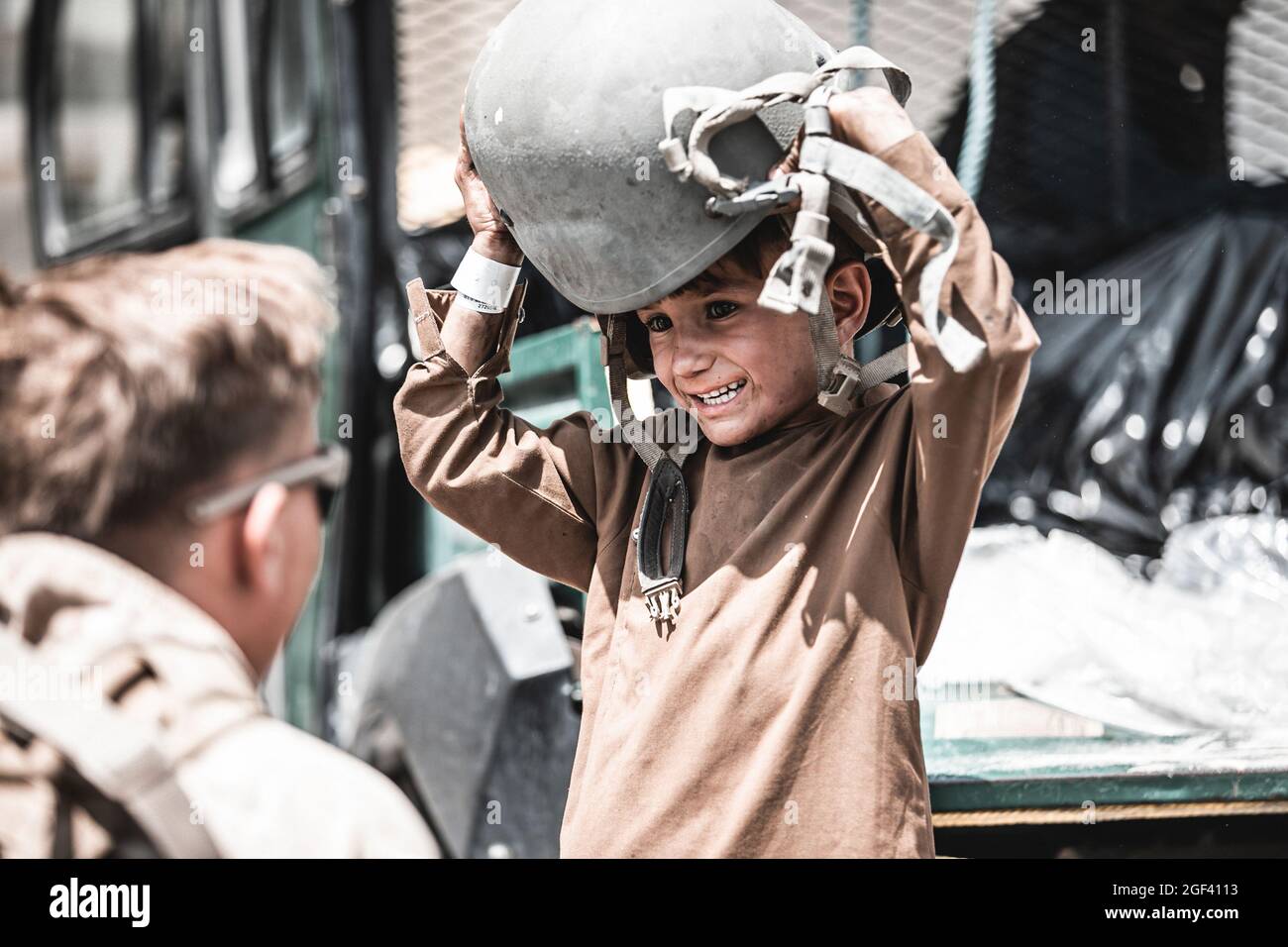 Kabul, Afghanistan. 23 Agosto 2021. Una Marina statunitense assegnata a Special Purpose Marine Air-Ground Task Force - Crisis Response - Central Command consegna un casco a un bambino in attesa di evacuazione all'aeroporto internazionale Hamid Karzai, a Kabul, Afghanistan, il 22 agosto, 2021. Gli Stati Uniti assistono il Dipartimento di Stato con un'operazione di evacuazione non combatante (NEO) in Afghanistan. Foto di Gunnery Sgt. Melissa Marnell/USMC/UPI Credit: UPI/Alamy Live News Foto Stock