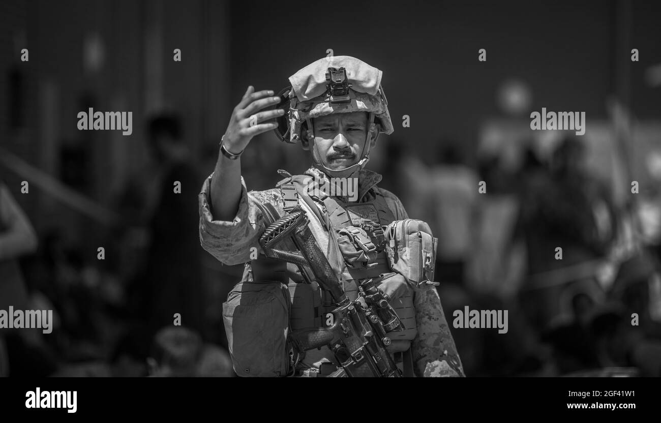 Una Marina con Special Purpose Marine Air-Ground Task Force-Crisis Response-Central Command (SPMAGTF-CR-CC) guida le famiglie durante un'evacuazione all'Aeroporto Internazionale Hamid Karzai, Kabul, Afghanistan, 23 agosto. I membri del servizio degli Stati Uniti stanno assistendo il Dipartimento di Stato con un prelievo ordinato di personale designato in Afghanistan. (STATI UNITI Foto del corpo marino di Sgt. Samuel Ruiz via American PhotoArchive/Alamy) Foto Stock