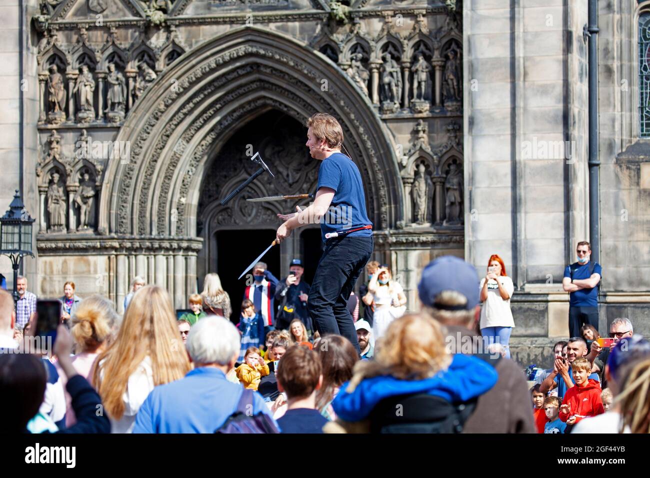 Edinburgh Fringe Festival, Edinburgh Royal Mile, Scozia, Regno Unito. 23 agosto 2021. La terza e l'ultima settimana della quale è stata ridotta a causa della pandemia di Covid-19. Ancora ragionevolmente occupato ma non come sarebbe stato negli anni precedenti.temperatura 19 gradi per i turisti e residenti fuori nel centro della capitale scozzese. Nella foto: Daniel Zindler si destina con un'ascia e coltelli in Piazza del Parlamento Ovest Foto Stock