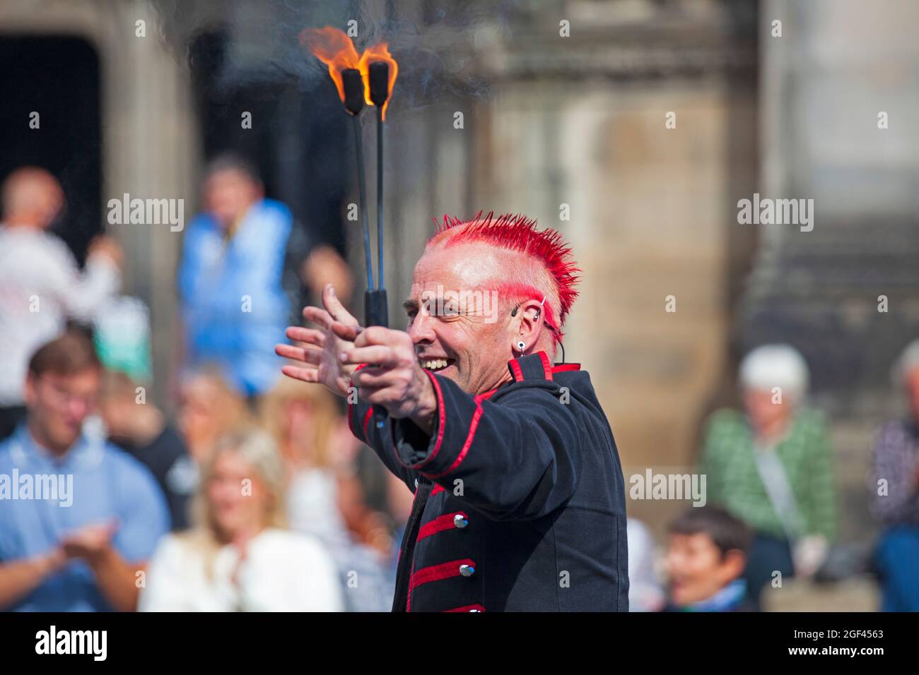 Edinburgh Fringe Festival, Edinburgh Royal Mile, Scozia, Regno Unito. 23 agosto 2021. La terza e l'ultima settimana della quale è stata ridotta a causa della pandemia di Covid-19. Ancora ragionevolmente occupato ma non come sarebbe stato negli anni precedenti.temperatura 19 gradi per i turisti e residenti fuori nel centro della capitale scozzese. Nella foto: Il Mighty Gareth dimostra che gli piace giocare con il fuoco a un pubblico apprezzata in Piazza del Parlamento Ovest. Credit: Arch White/Alamy Live News. Foto Stock