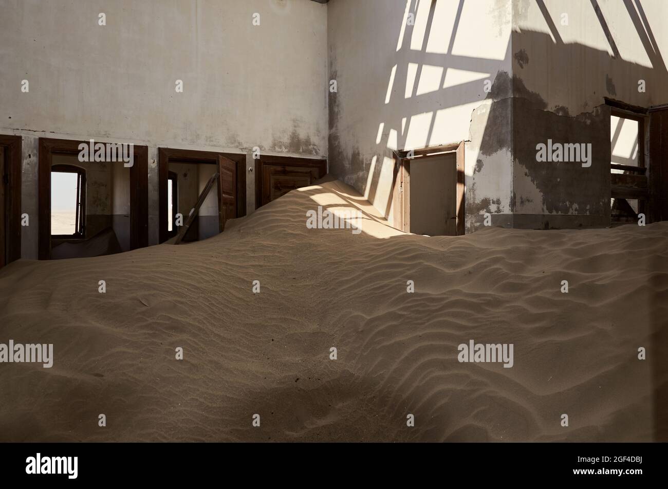 La sabbia ha invaso l'interno di un edificio abbandonato nella città fantasma Kolmanskop, Namibia, Africa meridionale. Foto Stock