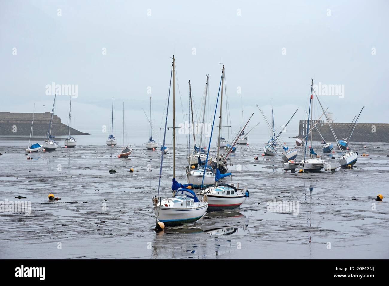 Piccole barche che riposano nel fango a bassa marea nel porto di Granton sul Firth of Forth, Edimburgo, Scozia, Regno Unito. Foto Stock