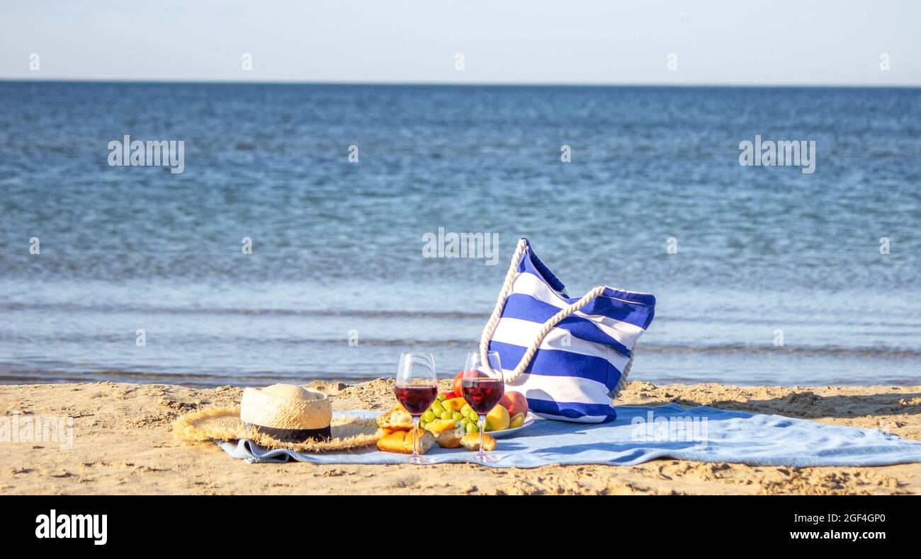 Coperta da picnic, vino, frutta, bella spiaggia di mare natura fuoco selettivo Foto Stock