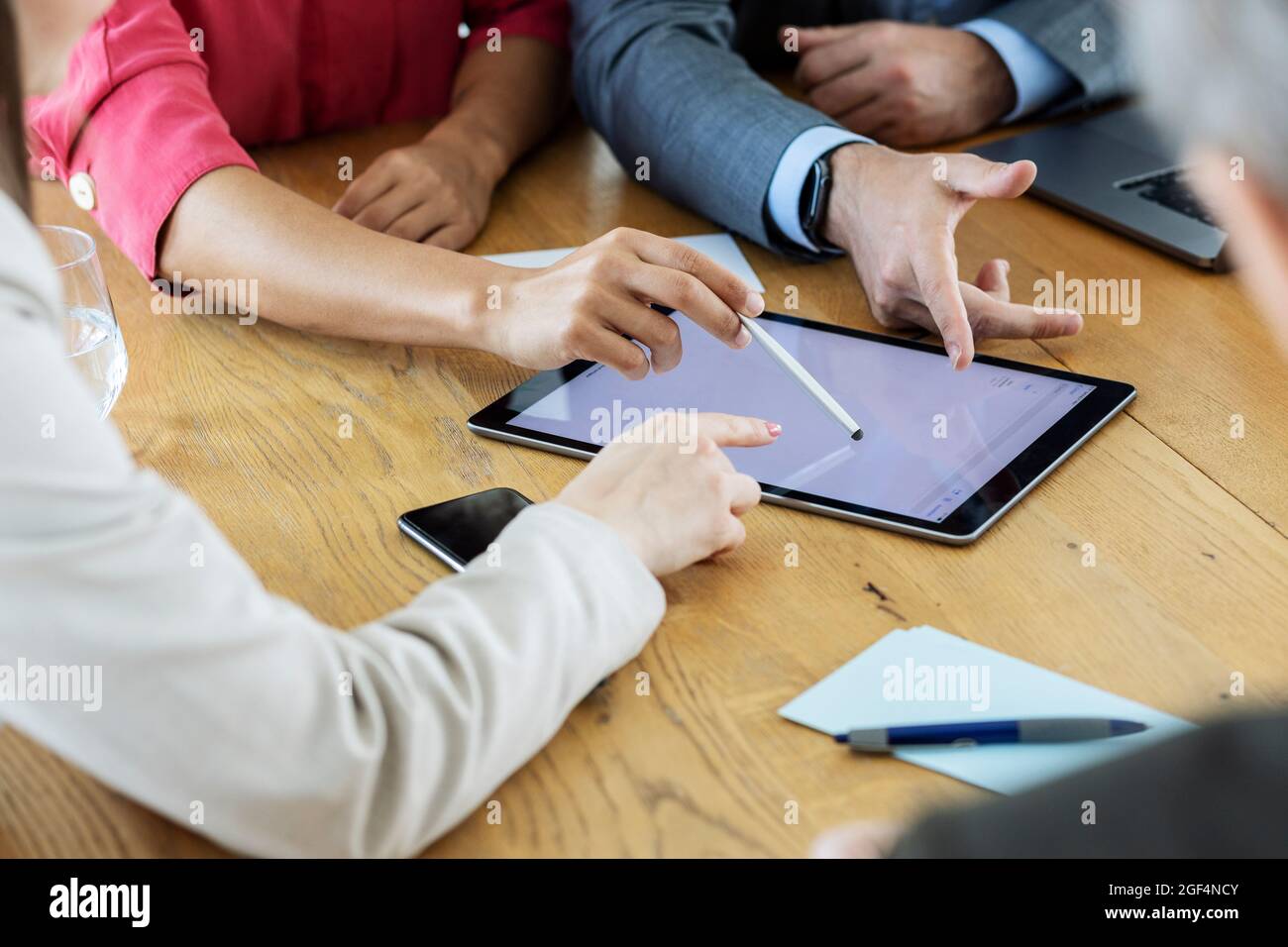 Colleghi che utilizzano un tablet digitale mentre lavorano insieme in ufficio Foto Stock