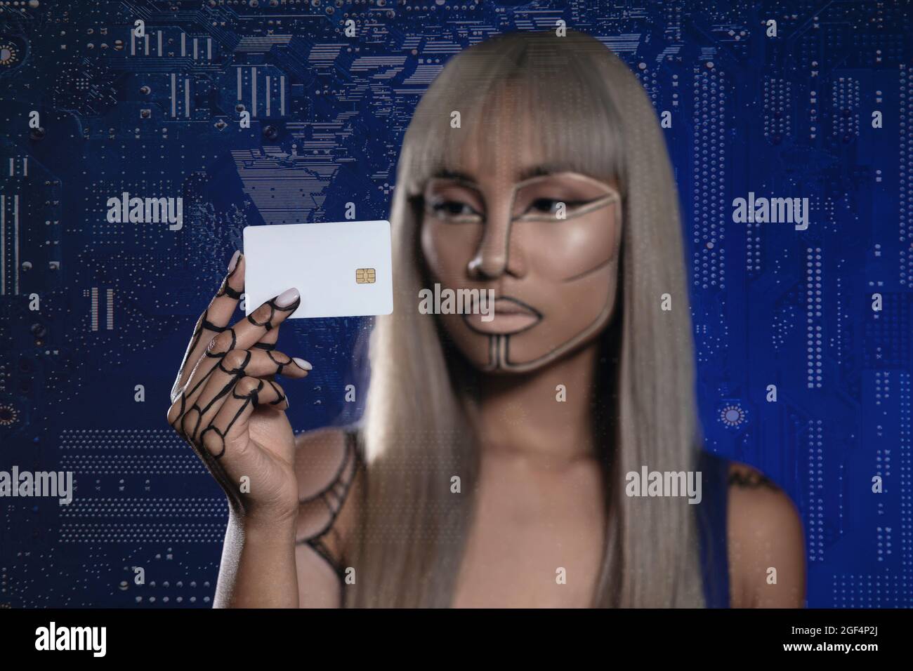 Robot femminile che guarda la carta di credito chip su sfondo blu Foto Stock