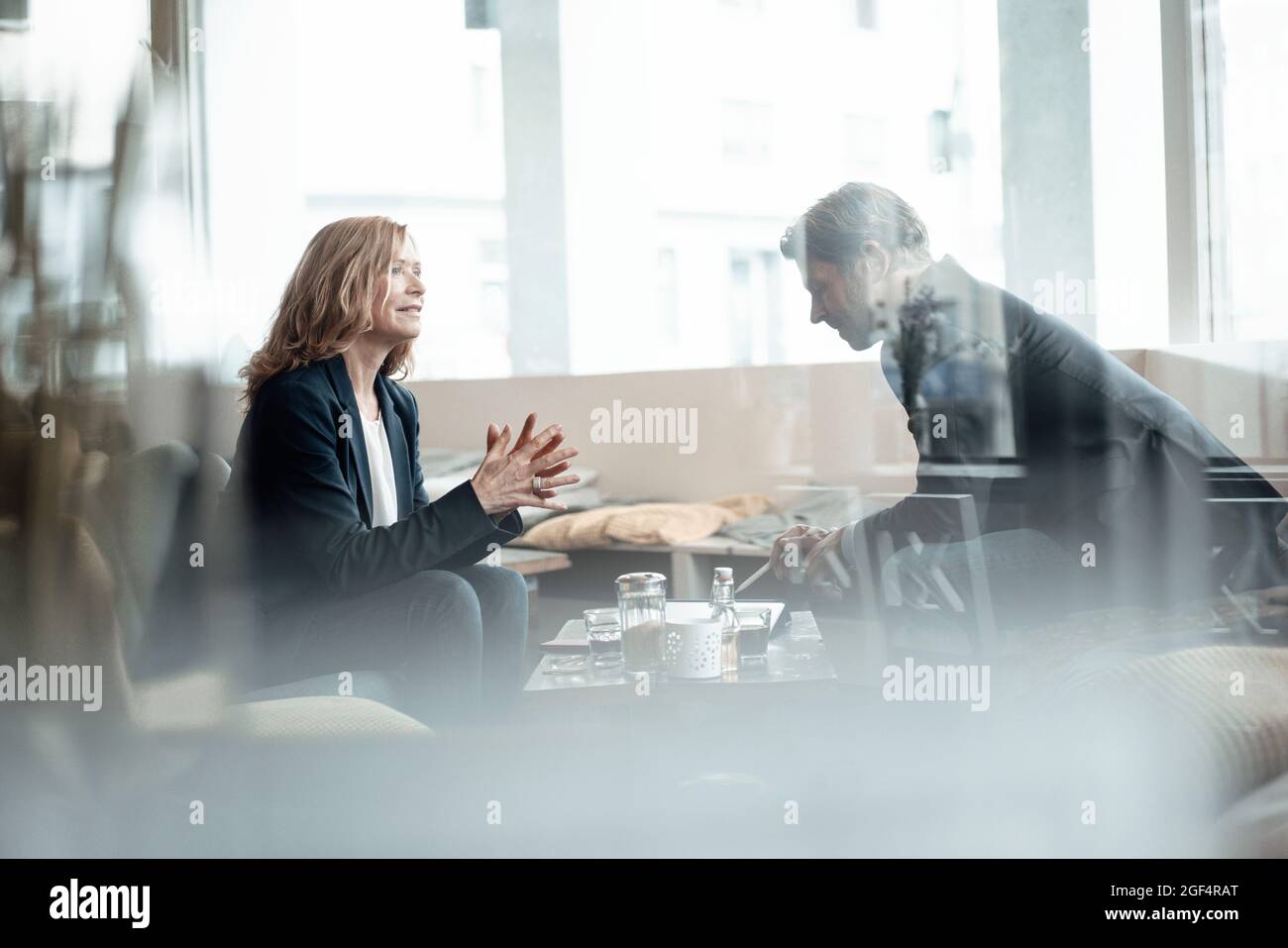 Professionisti di sesso maschile e femminile che discutono mentre condividono idee in un bar Foto Stock