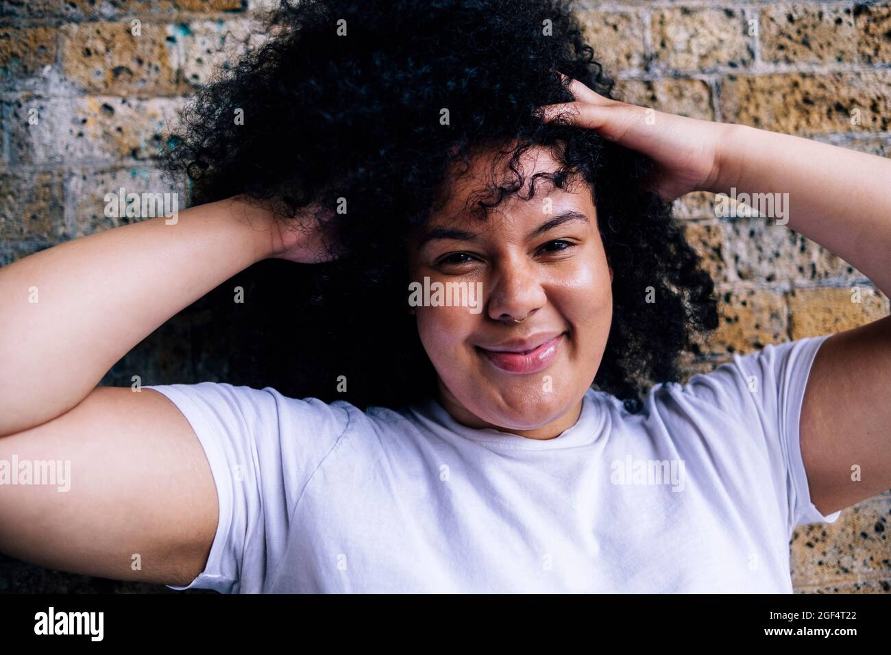 Giovane donna con le mani nei capelli Foto Stock