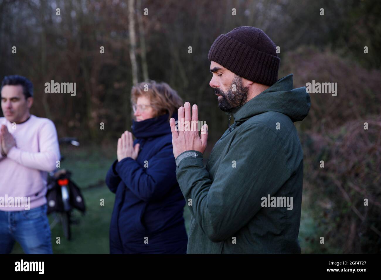 Donna matura e uomini con occhi chiusi meditando in natura Foto Stock