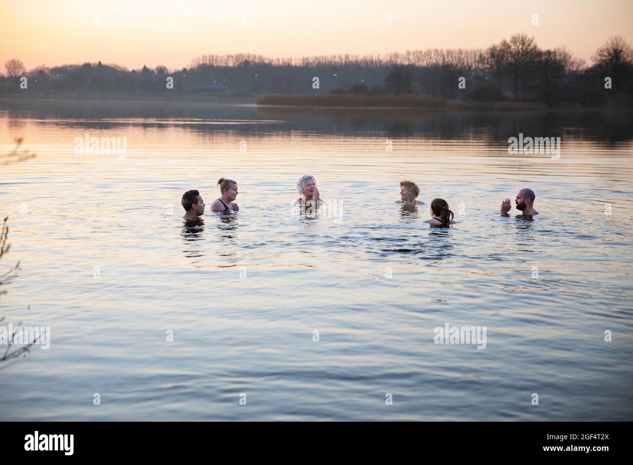 Uomini e donne che godono di acqua fredda al mattino Foto Stock