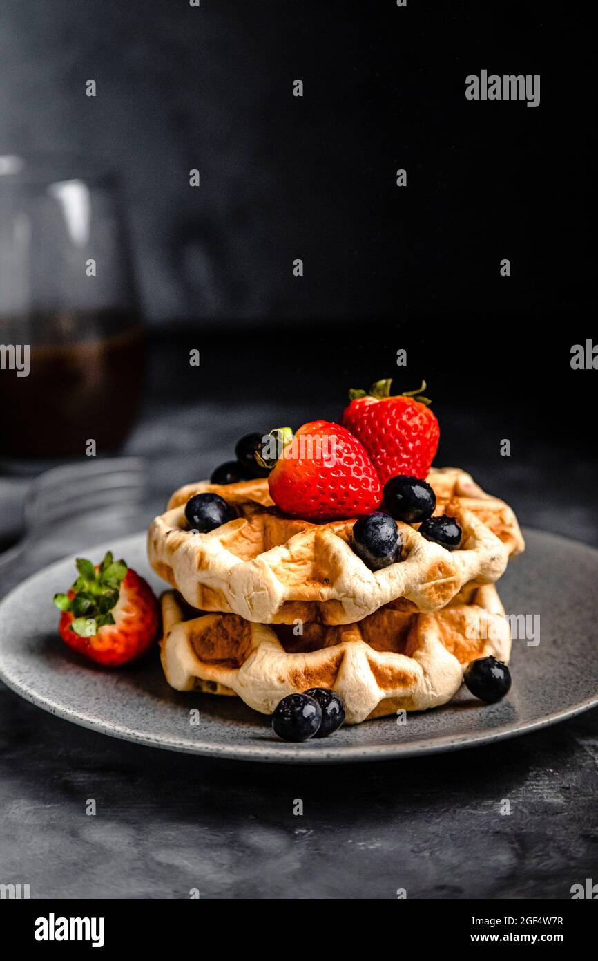 Piatto di waffle freschi con fragole e mirtilli Foto Stock