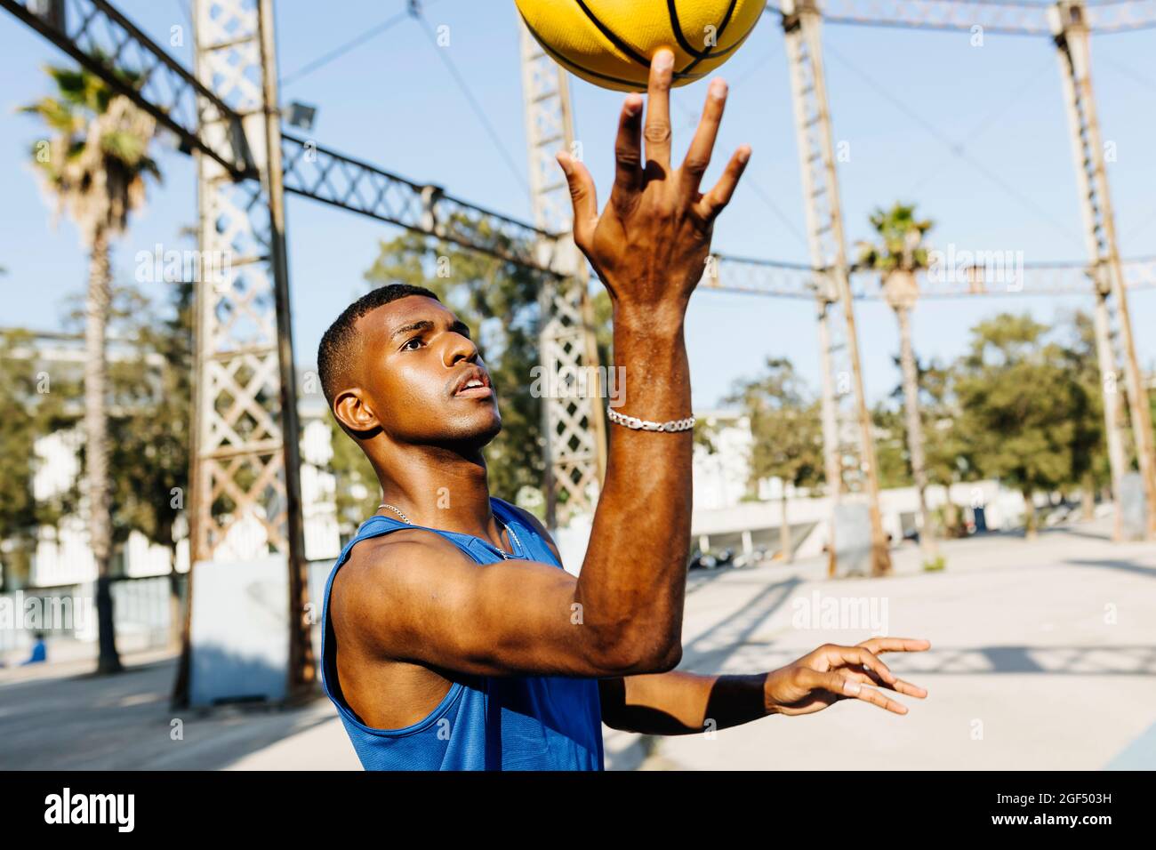 Uomo che gira basket a dito sul campo sportivo Foto Stock
