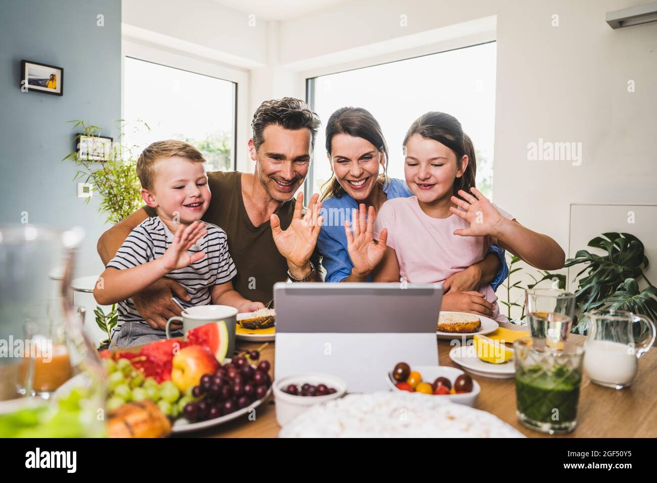 Saluto di famiglia durante le videochiamate sul tablet digitale di casa Foto Stock