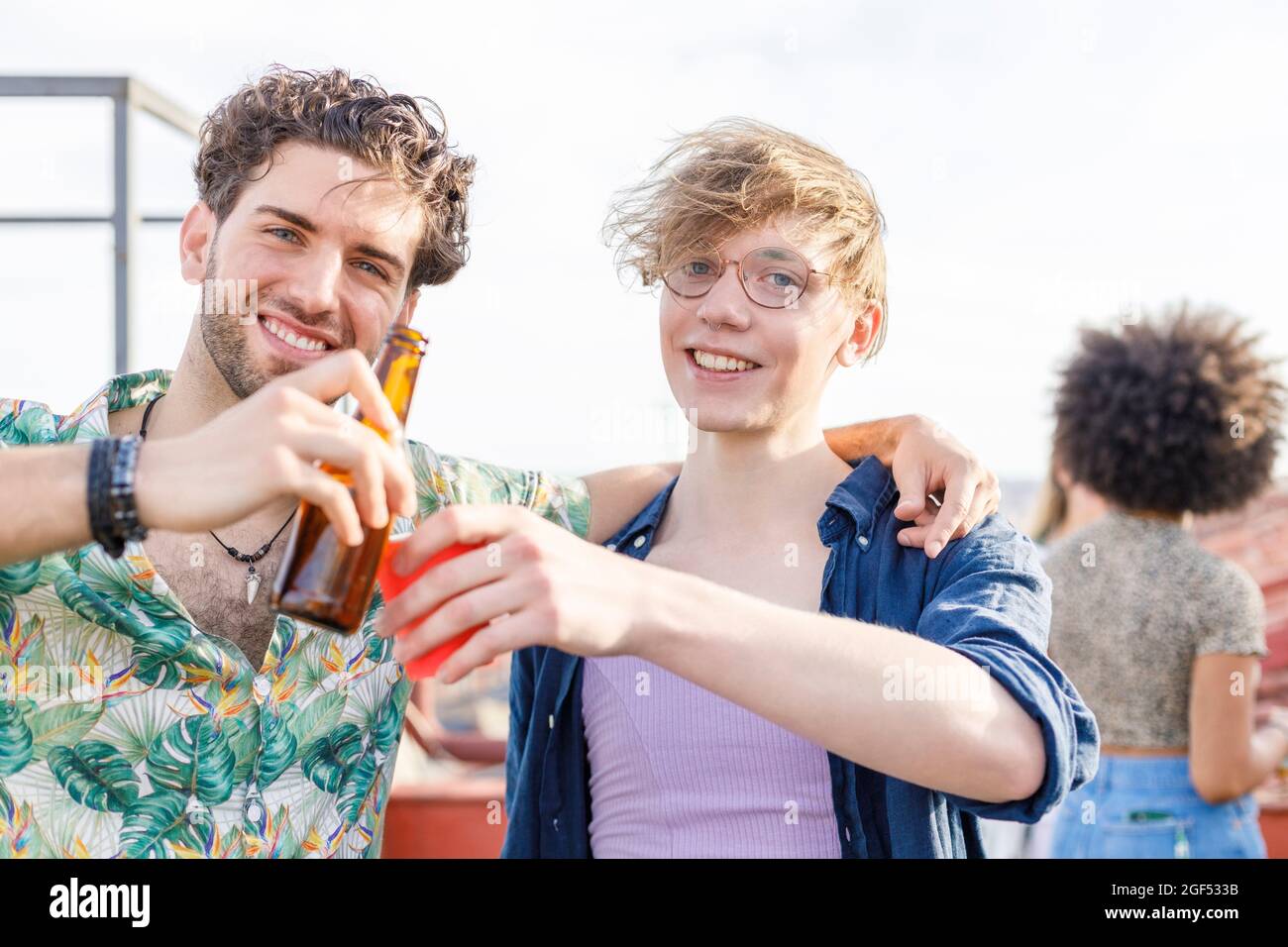 Amici sorridenti che tostano bevande durante la festa Foto Stock
